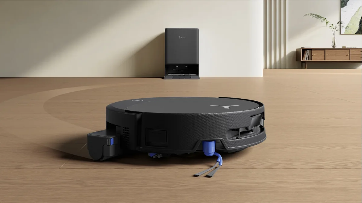 Black ECOVACS DEEBOT T90 PRO OMNI robot vacuum on a wood floor with its dock behind it