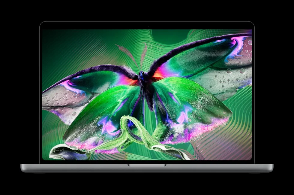 Open MacBook Pro shown from the front with a green butterfly on its display against a black background