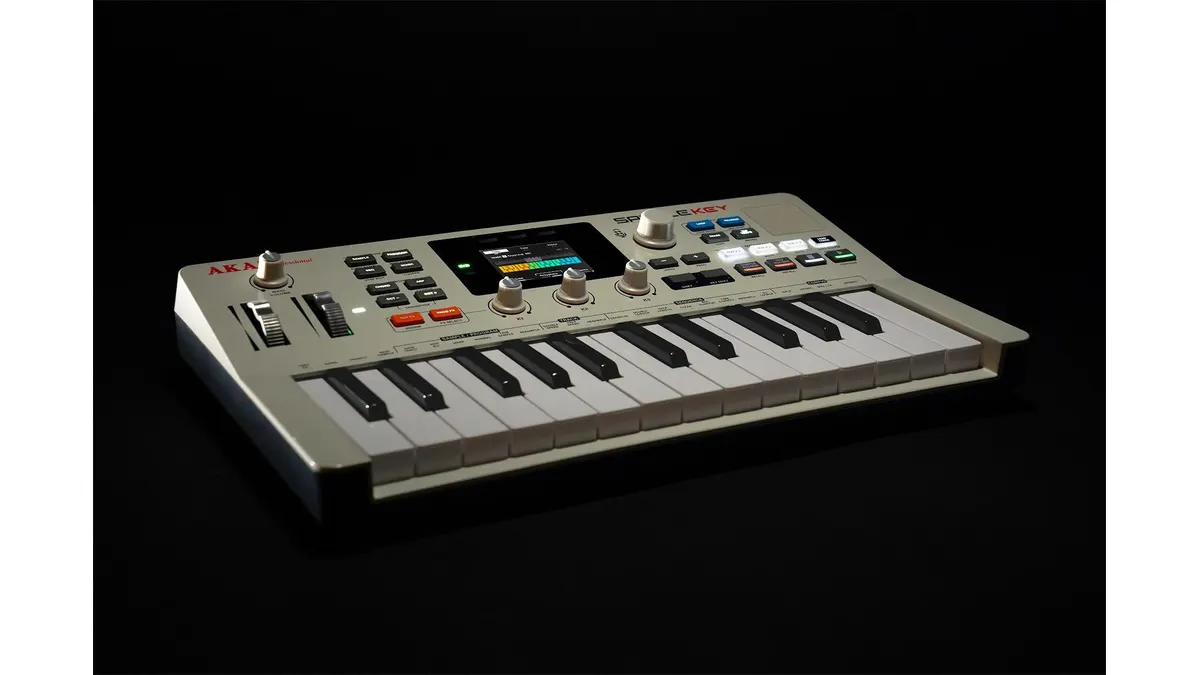 Akai MPC Sample Key keyboard sampler with white and black piano keys, pitch and modulation wheels, central display, and multiple sampling controls against a dark background.