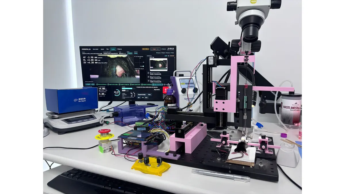 Exin Therapeutics' experimental laboratory setup with computer display, microscope, robotic positioning equipment, and a mouse undergoing a research procedure.