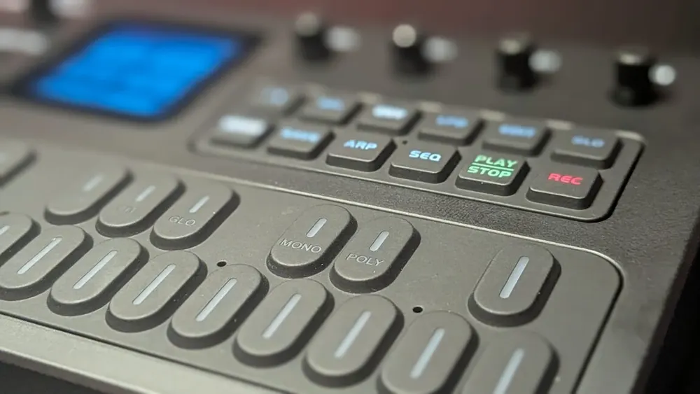 M-Vave FM-1 portable handheld synthesizer showing rubberized keys, rotary encoder, and illuminated OLED screen