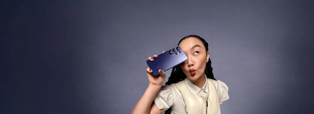 A person holding the Galaxy S26 Ultra in Cobalt Violet, with the camera lenses visible.