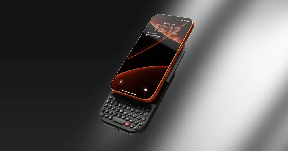 Official product rendering of the Clicks Power Keyboard attached magnetically beneath an iPhone, sliding out to reveal a tactile QWERTY keyboard