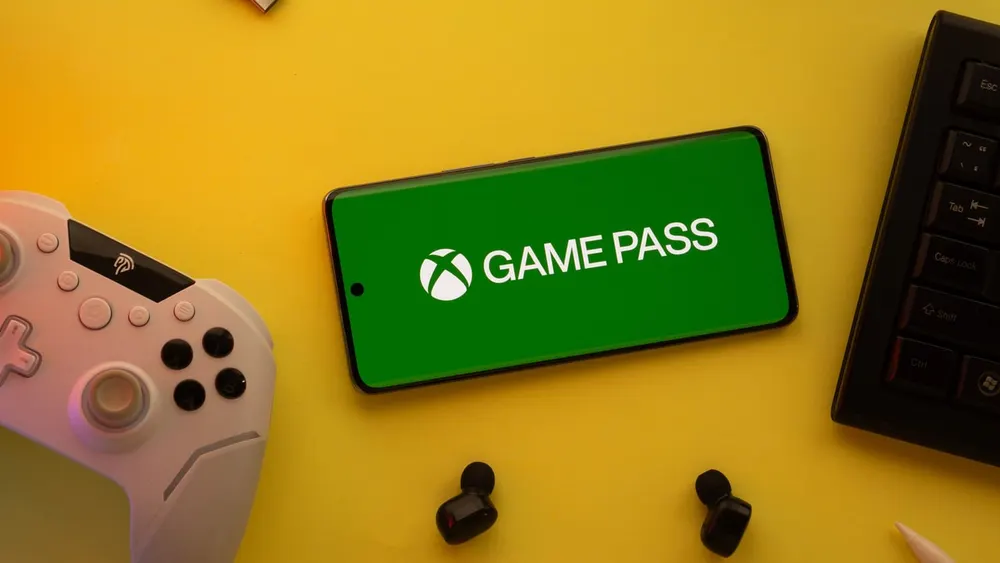 Modern wireless Xbox controller resting beside the Xbox Game Pass user dashboard and cloud library