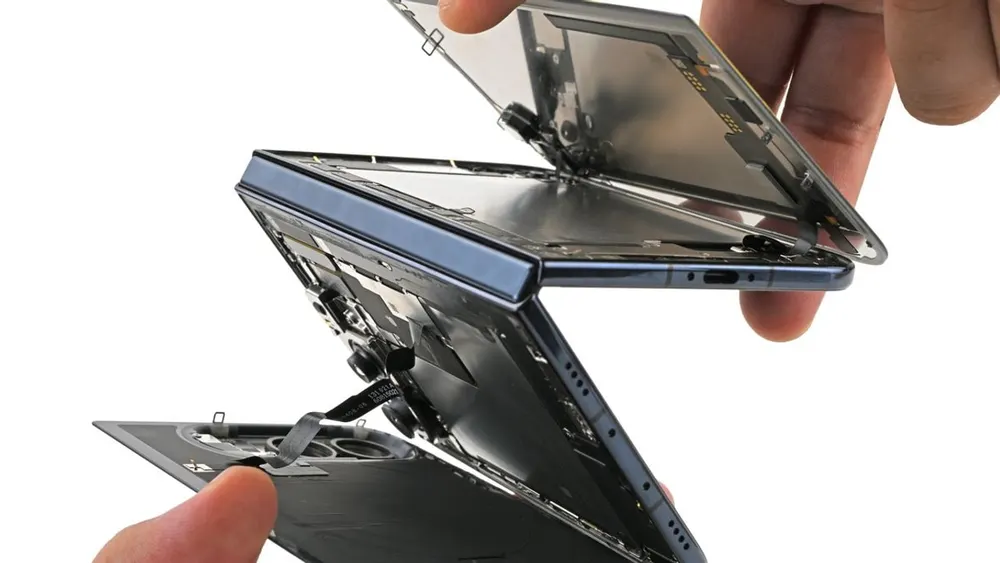 Detailed teardown view of the Apple iPhone Duo foldable hinge mechanism and ultra-thin glass substrate